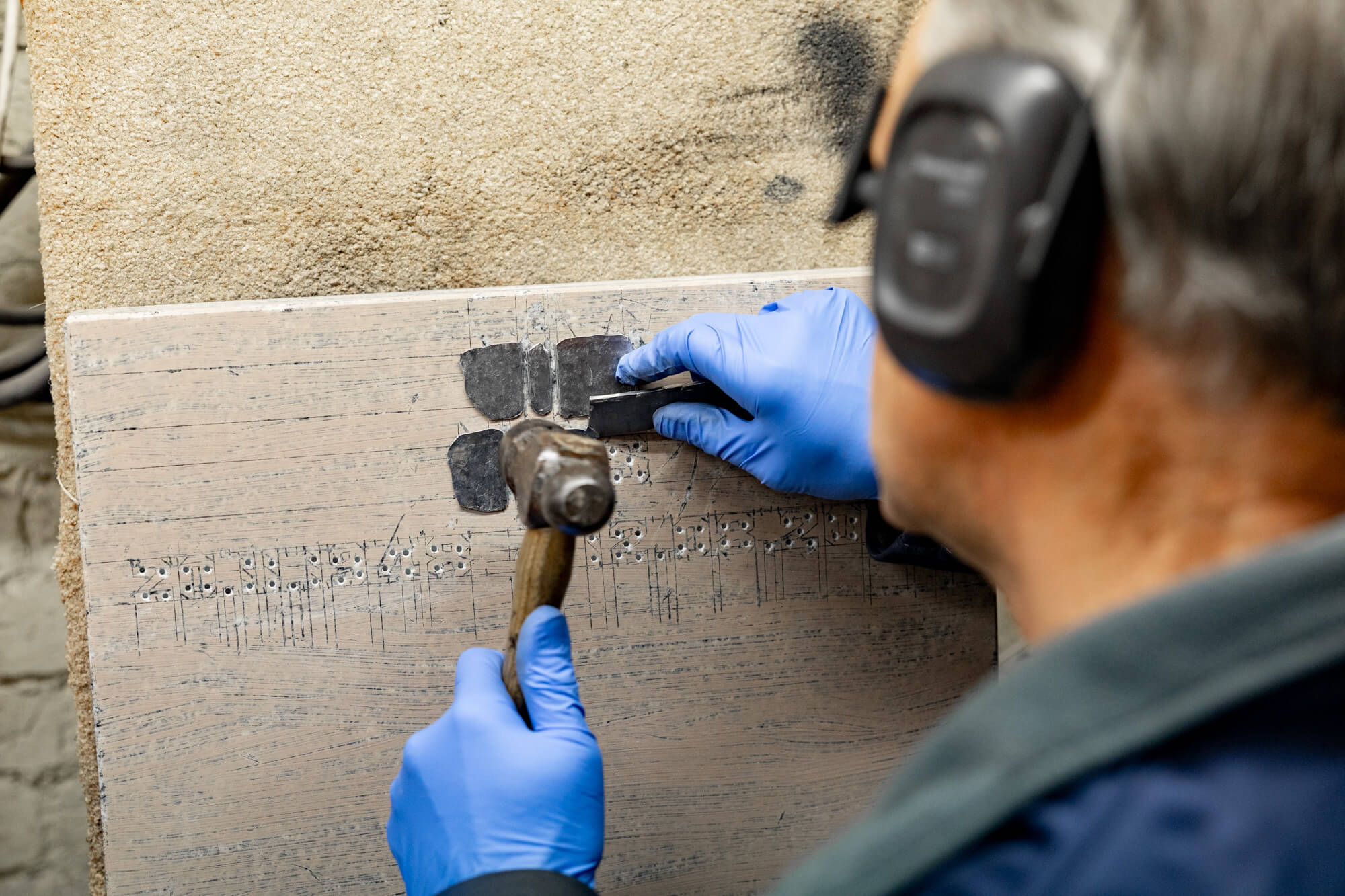 In-Laid Lead being worked into the lettering carved in the stone at Fine Memorials Bridgwater workshop – stonemasons hand-carving headstones and memorials
